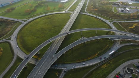 an aerial view a large roundabout on the outskirts of the city with several bridges for cars and trucks