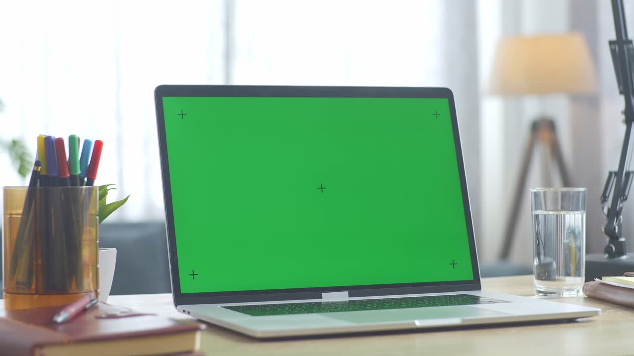 Laptop with Green Screen on a Desk