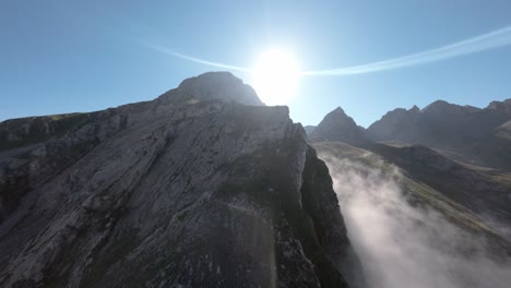 scharfe gipfel von felsigen bergen und heller sonnenschein, aerial fpv-ansicht