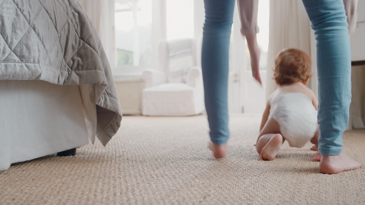 bebé feliz gateando niño explorando con curiosidad en casa con la madre recogiendo suavemente a su bebé ayudando al niño responsabilidad de la maternidad 4k