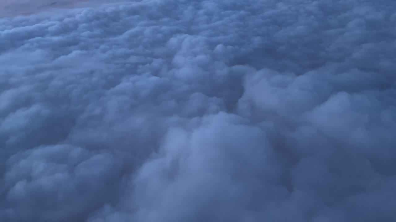 Scene of plane trip over clouds. Passenger POV, real time