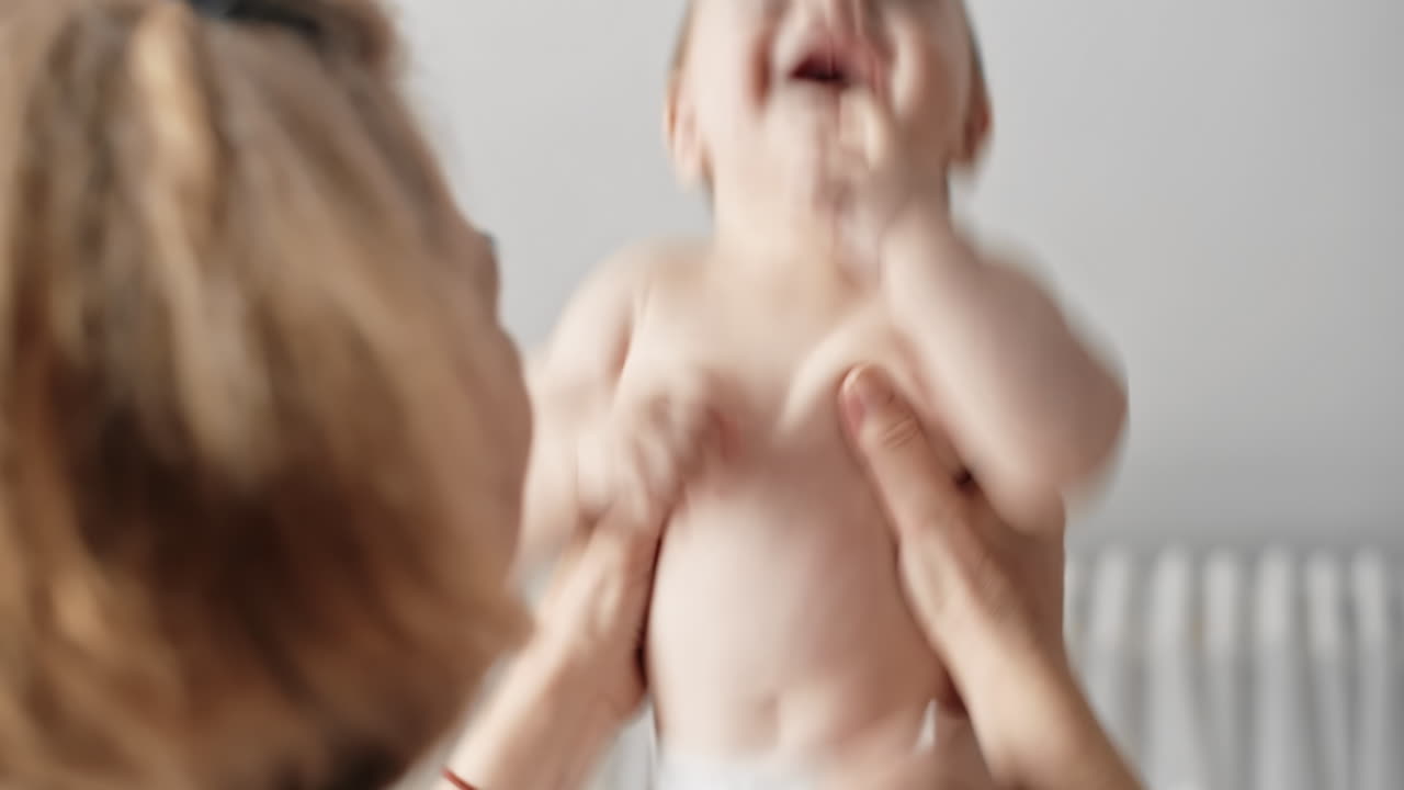 Mom throws the baby boy up. Happy kid