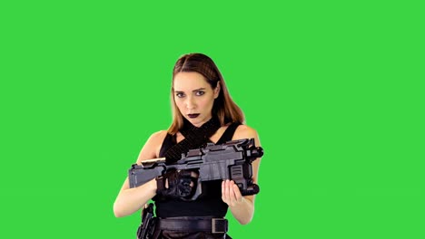 chica con camiseta negra y falda de cuero posa con un arma en las manos, haciendo sí en una pantalla verde, llave de croma