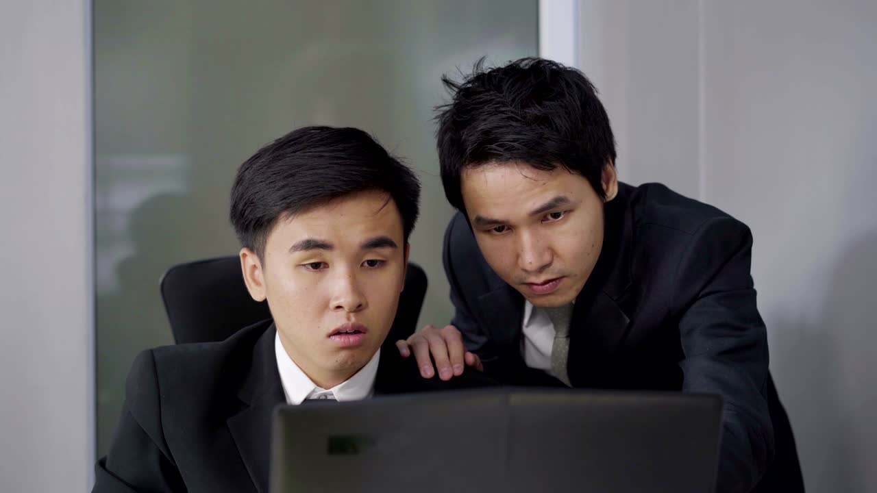 두 명의 행복한 사업가가 노트북 컴퓨터를 사용하여 성공적인 작업 프로젝트를 수행합니다.