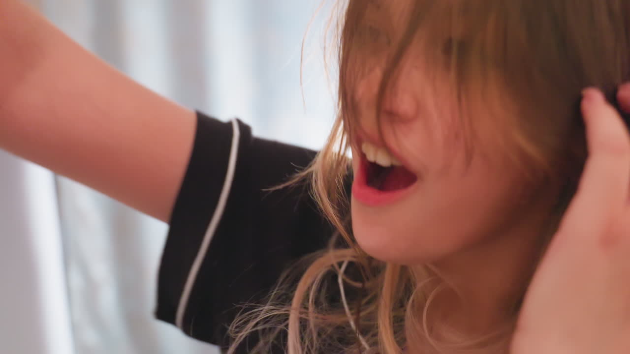 Close up of brunette girl with subtle smile and wide eyes showing playful surprise while reacting to soft pillow hit during fun indoor moment