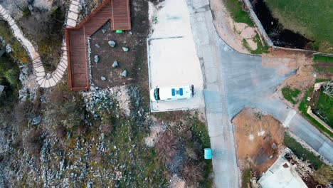 un dron en ascenso disparado sobre una autocaravana blanca modificada para la vida nómada, el trabajo remoto y los viajes de aventura se encuentra estacionado en un mirador