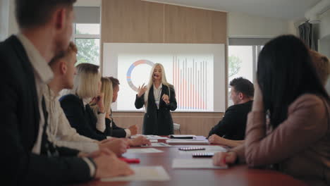 female seo specialist is speaking in business conference standing against charts and diagrams