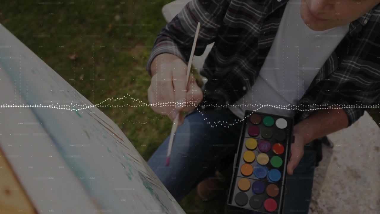 Pintor selecionando pigmento após olhar para a paleta e aplicando pinceladas de aquarela na tela para arte.