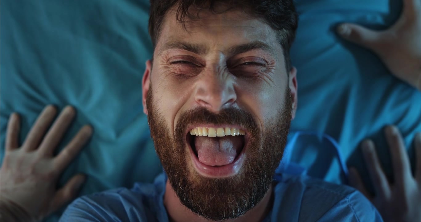 Primo piano di un uomo barbuto felice che ride con la lingua di fuori