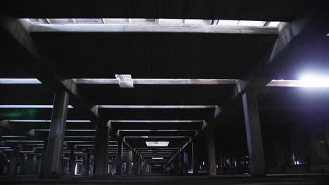 Empty-abandoned-building-skeleton,-concrete-pillars-and-pools-of-water