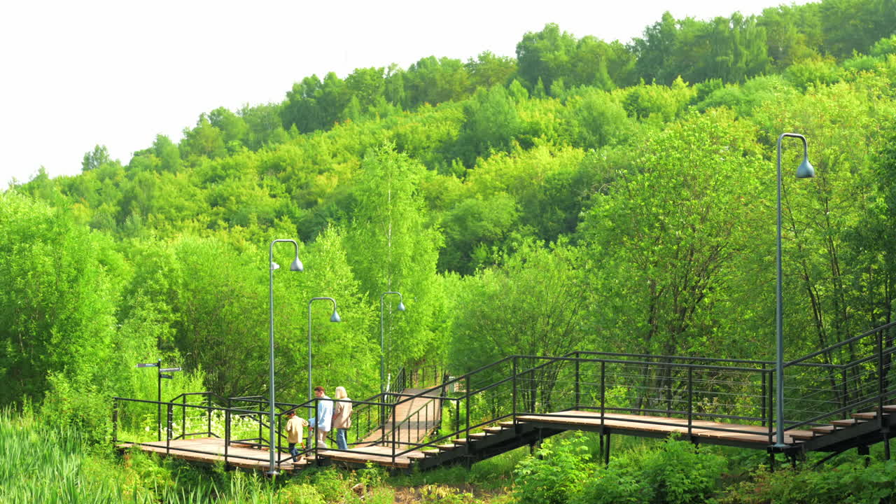 Family walking on a bridge in a green park