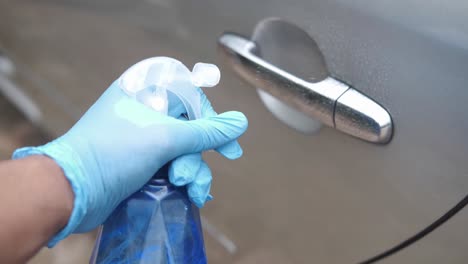 washing a car door with a spray bottle