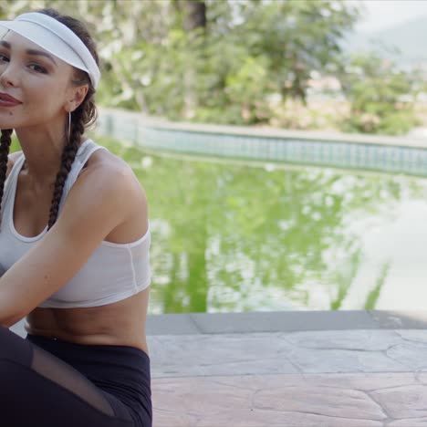 deportista alegre sentada junto a la piscina