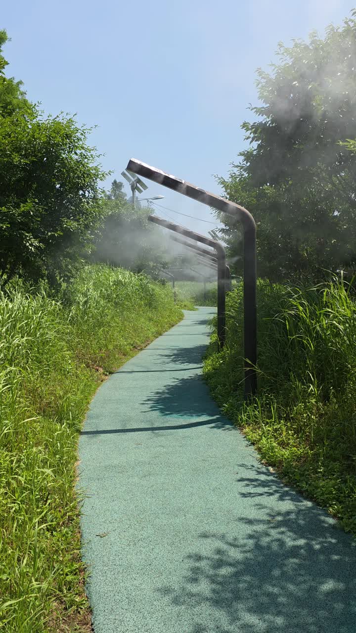 A cooling mist system with fogger nozzles sprays a fine water vapor to lower the temperature on a public walkway in Yangjae Stream Park in Seoul, South Korea, to combat the summer heat