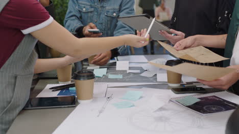 close-up-young-engineers-developing-bicycle-prototype-using-blueprint-schematics-students-brainstorming-future-development-collaborating-sharing-creative-ideas-in-trendy-office