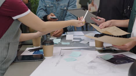 cerca de jóvenes ingenieros desarrollando prototipos de bicicletas usando esquemas de planos estudiantes haciendo lluvia de ideas sobre el desarrollo futuro colaborando compartiendo ideas creativas en la oficina de moda