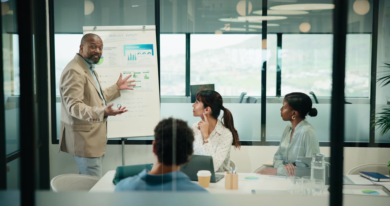 Mature Businessman Giving Presentation to Colleagues in Modern Office