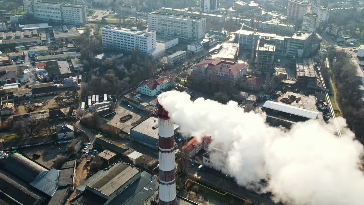 Aerial drone view of Chisinau. Thermal station with smoke coming out of the tube. Buildings, roads and bare trees. Good weather. Moldova