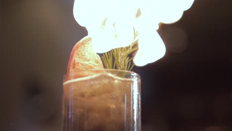 close-up shot of a drinks garnish being roasted from a blowtorch