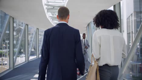 business people interacting with each other in the corridor at office 4k