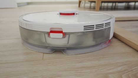 white robot vacuum cleaner performs automatic cleaning of the apartment, modern technology of smart cleaning.