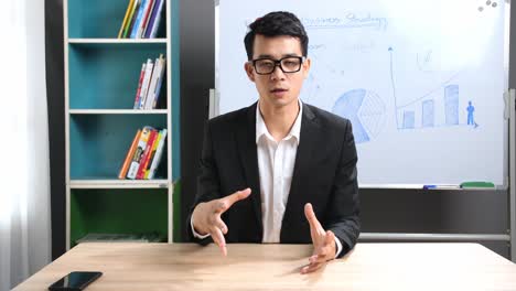 asian businessman talking to camera
