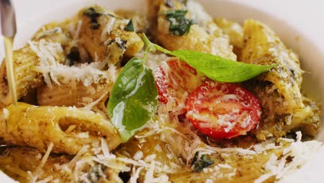 pasta penne con pesto, pomodori ciliegino e parmigiano