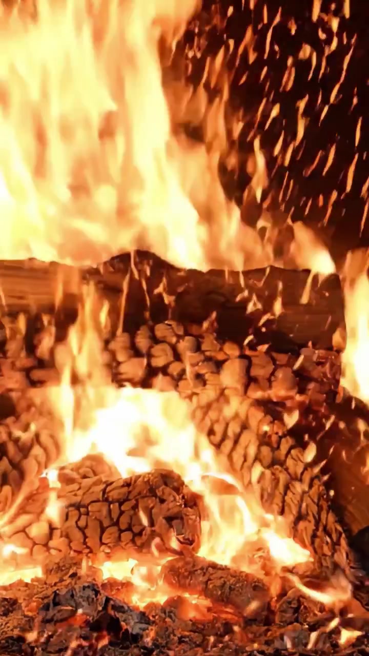 L'affascinante danza delle fiamme: uno sguardo ravvicinato a un camino scoppiettante, che mette in risalto il calore e il bagliore dei ceppi e delle braci ardenti