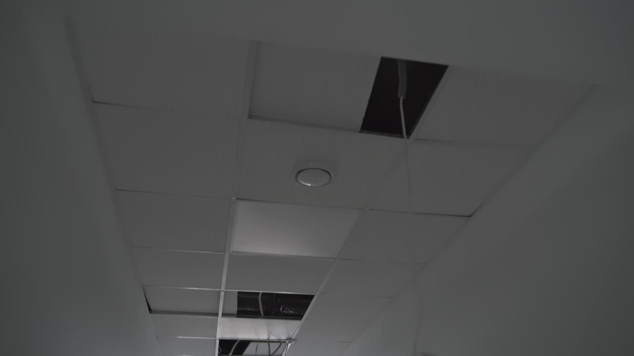 Recently built premises with unfinished inside works. Light system in the process of installation. Wires hanging from the ceiling.