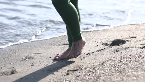 Woman walking barefoot on the beach