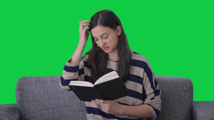 chica india confundida escribiendo un libro pantalla verde