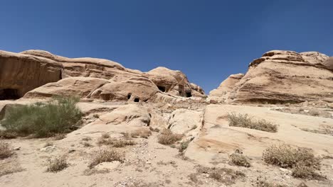 Petra-valley-in-Wadi-Musa,-Jordan-with-The-Treasury-in-the-middle-of-a-rocky-and-mountainous-landscape,-an-UNESCO-heritage-site,-ancient-Nabatean-Kingdom-4K-Establish-Shot