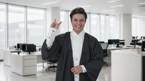 abogado indio feliz mostrando el signo de la victoria