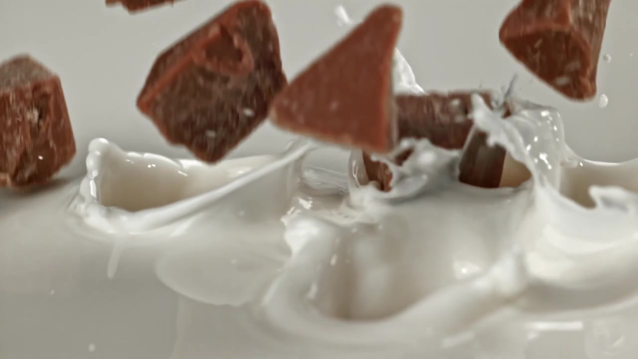 Chocolate Chunks Dropping into Creamy White Milk in Slow Motion