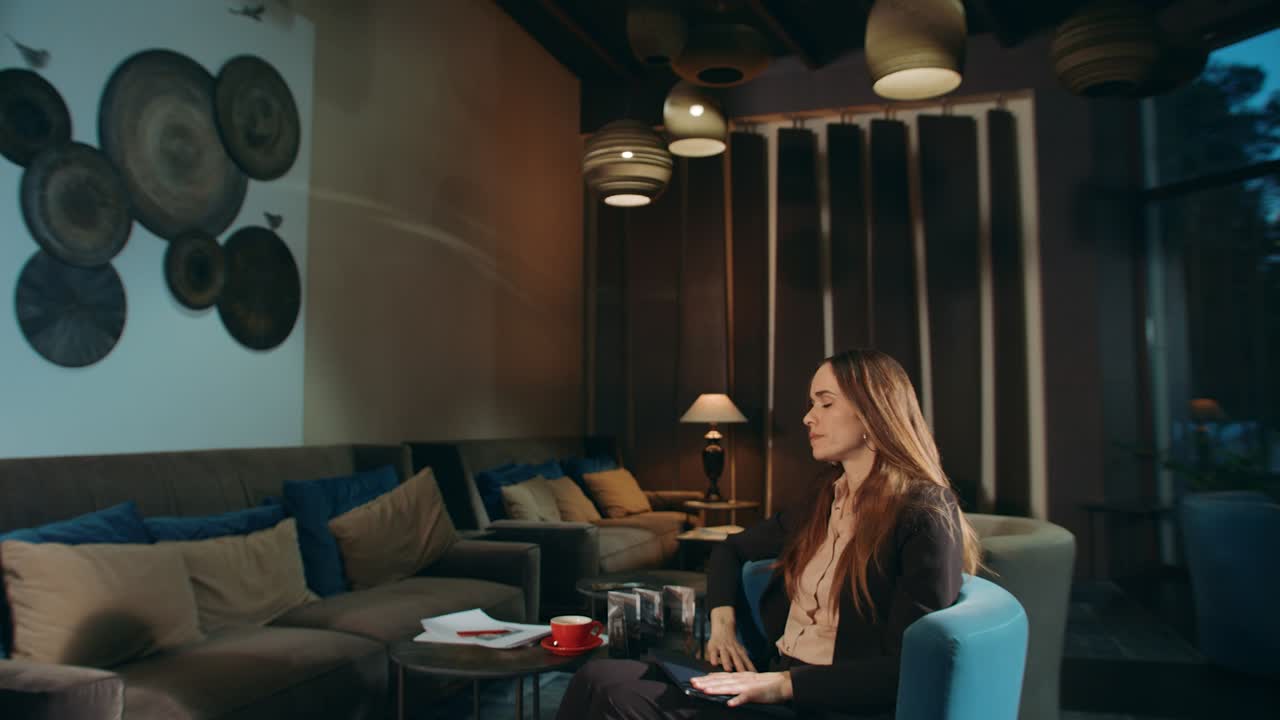 호텔 로비에서 노트북 컴퓨터를 닫고 있는 피곤한 여자. 카페에서 피곤한 여자