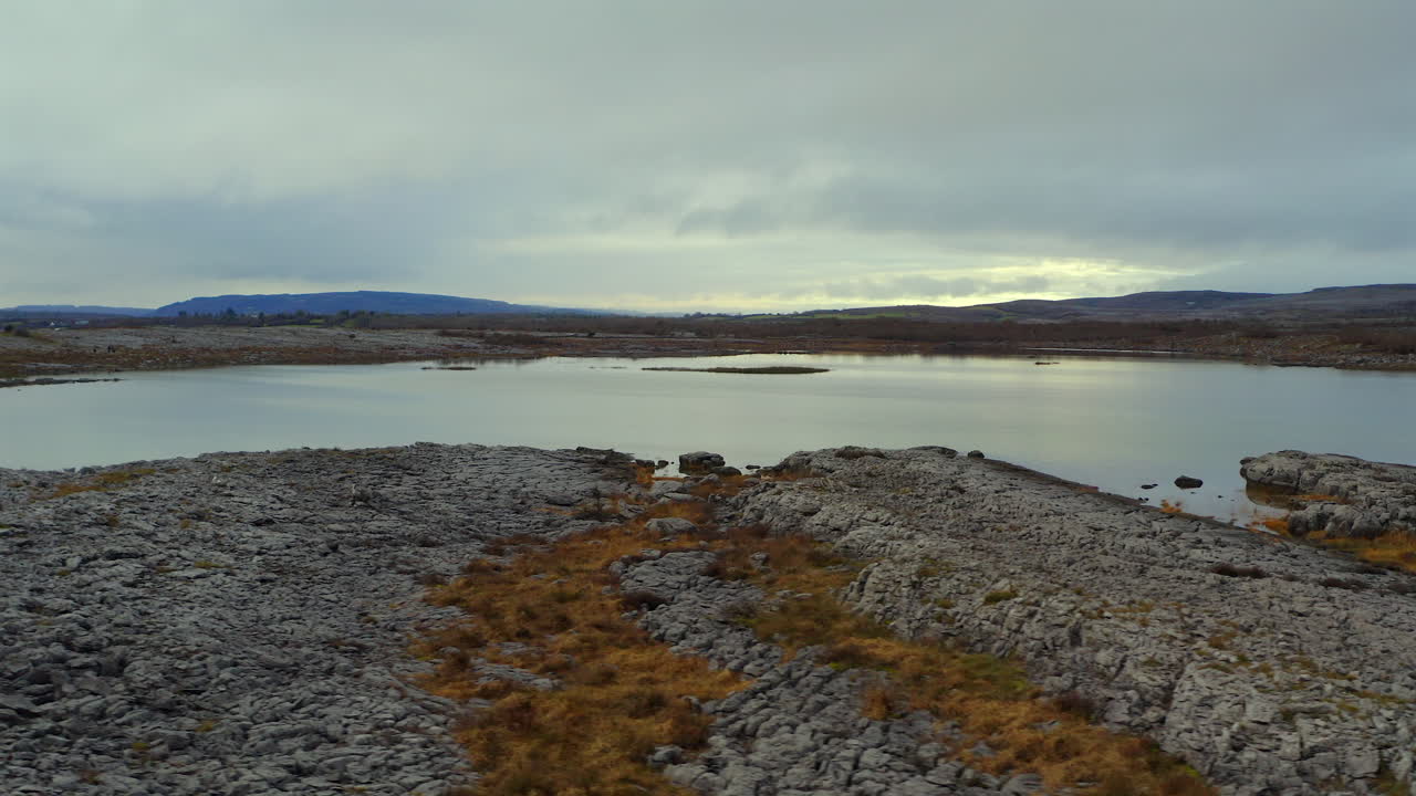 impresionante panorámica aérea tomada cerca del suelo con un gran lago estacional en el burren. condado de clare