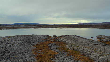 impresionante panorámica aérea tomada cerca del suelo con un gran lago estacional en el burren. condado de clare