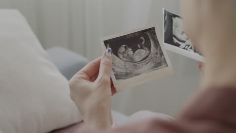 woman looking at ultrasound images of baby