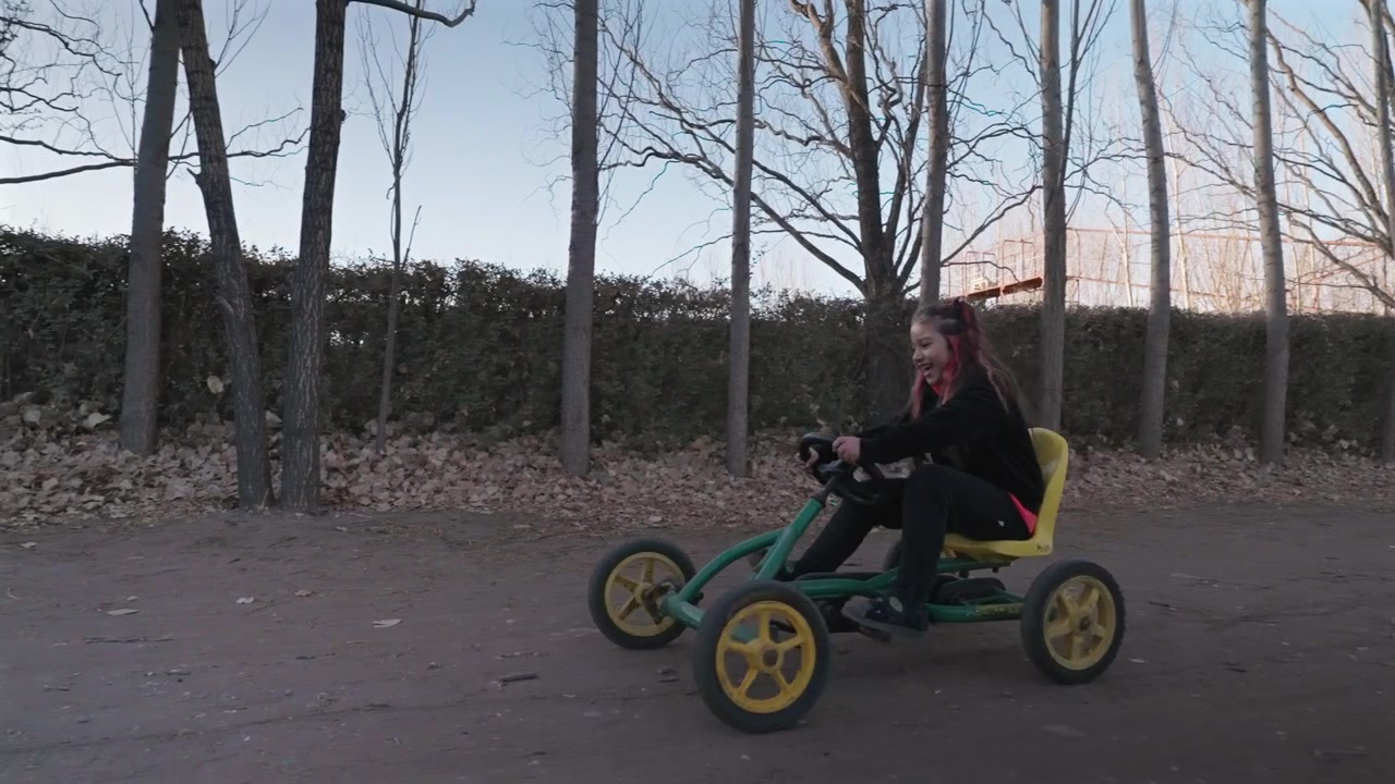 Glad barn kører på en pedalkart og nyder aktiv udendørs leg og eventyr