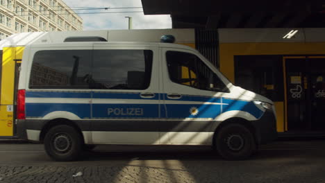 urban tram and a police car drive by in berlin, germany