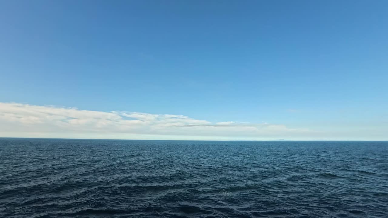 Stort blåt ocean og himmelhorisont med blide bølger