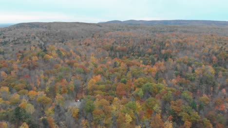 Small-pond-in-a-forest-in-the-Gatineau-Hills-beside-pink-Lake-aerial-footage-reversing-away-from-the-hills-covered-in-trees