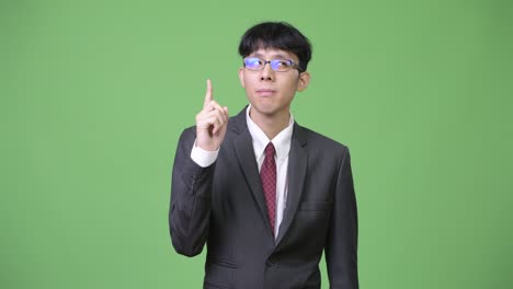 young asian businessman thinking while pointing finger up