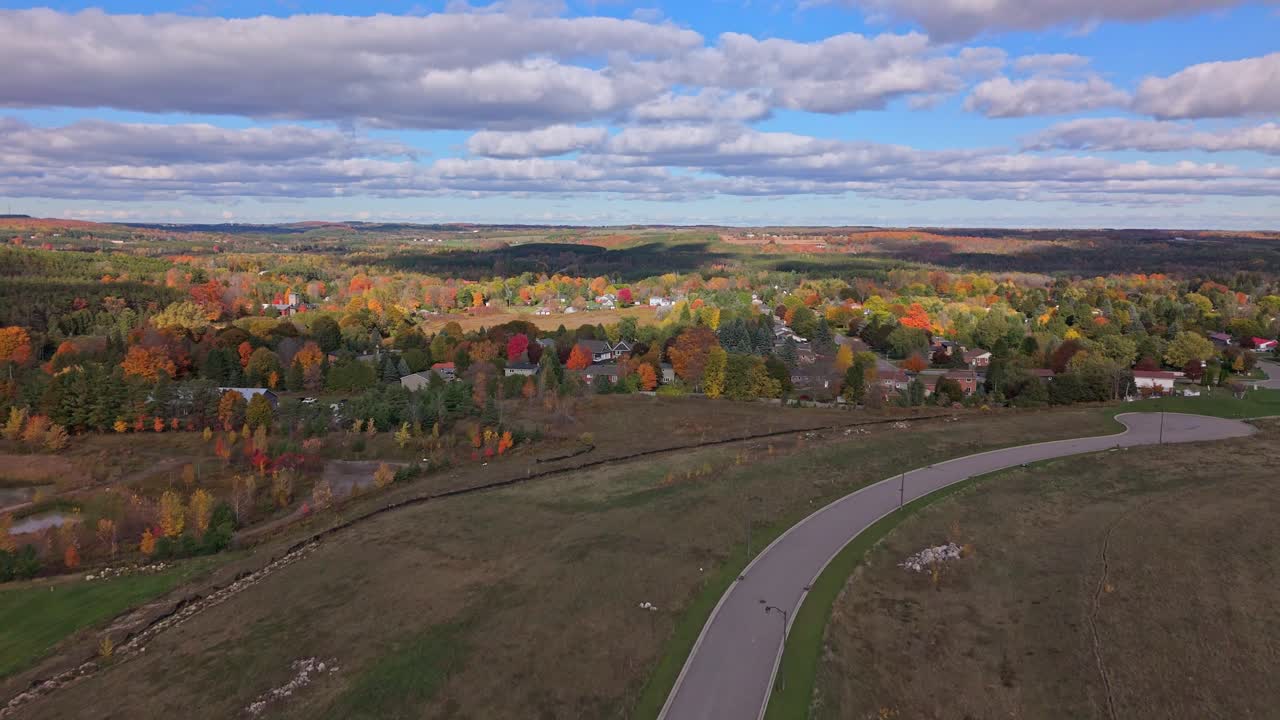 Vista aerea da drone della città rurale di Alton, in Ontario, in autunno, con fogliame autunnale colorato e nuovi complessi residenziali visibili, che riflettono crescita, espansione della community e cambiamenti dei paesaggi rurali