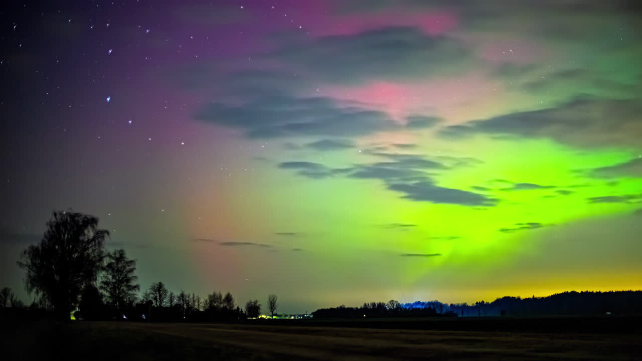 vibrante aurora boreal bailando sobre el paisaje sereno por la noche, toma de lapso de tiempo capturando la exhibición celestial