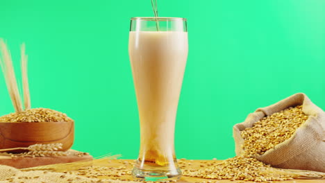 pouring beer into a glass with wheat grains
