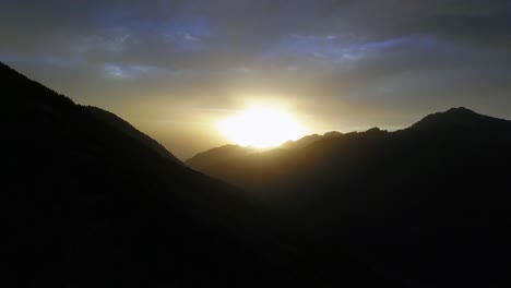 Aerial-drone-view-of-a-beautiful-fall-sunset-with-the-sun-gleaming-over-the-mountain-timberline-in-the-Utah-Rocky-Mountains