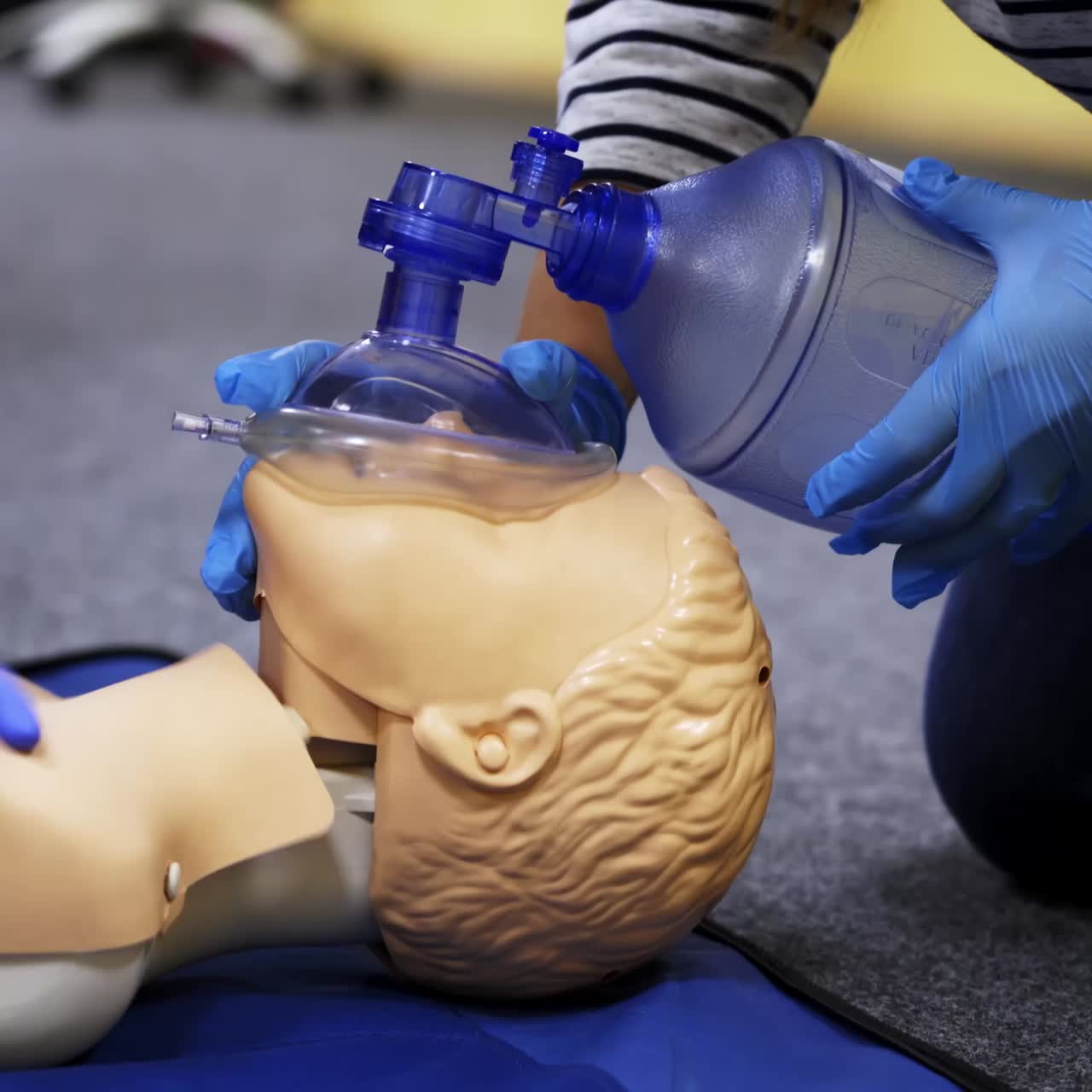 Training course on a manikin. Practitioners giving breath exercises on a dummy at resuscitation. Compression during heart attack on a mannequin