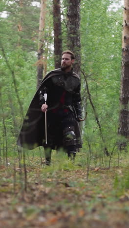 knight in chain mail walks through forest with bow and arrow, historical role-playing games and costumes