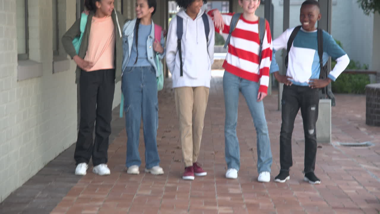 Diverse group of multiracial students smiling with backpacks, enjoying time at school